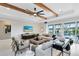 Bright living room with shiplap wall, ceiling beams, and view to outdoor pool area at 15919 Winding Bluff Dr, Montverde, FL 34756