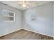 A bright bedroom with two windows, wood-look floors, textured ceiling tiles, and neutral walls at 1707 Wilton Ave, Orlando, FL 32805