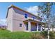 Exterior of two-story home with a covered patio, green lawn, and a tree providing shade at 1722 Lake Sims Pkwy, Ocoee, FL 34761