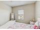 Bedroom featuring a bed with pink and white bedding and a window with blinds at 1722 Lake Sims Pkwy, Ocoee, FL 34761