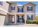 Inviting front porch with a seating area, sleek black railings, and manicured landscaping at 1722 Lake Sims Pkwy, Ocoee, FL 34761