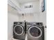 Modern laundry room with side-by-side washer and dryer, and wire shelving at 1722 Lake Sims Pkwy, Ocoee, FL 34761