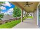 Covered patio featuring ceiling fans overlooking a lush, landscaped backyard at 1722 Lake Sims Pkwy, Ocoee, FL 34761