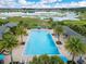 Aerial view of a large community pool surrounded by palm trees and lounge chairs at 1722 Lake Sims Pkwy, Ocoee, FL 34761