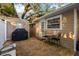 Backyard patio area featuring barbecue grill, dining set, stamped concrete, and lush landscaping at 1818 S Oak Ave, Sanford, FL 32771