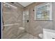 Modern bathroom with a glass shower, herringbone tile, and natural light at 1818 S Oak Ave, Sanford, FL 32771