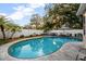 Backyard pool with patio and lounge seating surrounded by lush landscaping and a white privacy fence at 1818 S Oak Ave, Sanford, FL 32771