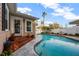 Backyard pool with patio, lounge seating, white fencing, and lush landscaping next to the house at 1818 S Oak Ave, Sanford, FL 32771