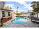 Backyard pool surrounded by patio with lounge seating, white fencing, palm trees, and lush landscaping at 1818 S Oak Ave, Sanford, FL 32771