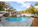 Inviting backyard pool area surrounded by stamped concrete, lush trees, and a privacy fence at 1818 S Oak Ave, Sanford, FL 32771