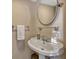 Cozy powder room with a pedestal sink and decorative mirror at 1818 S Oak Ave, Sanford, FL 32771