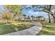 Scenic community park featuring lush green spaces, walking path, picnic tables, and mature trees, perfect for outdoor activities at 1883 Blissful Dr, Kissimmee, FL 34744