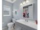 Neutral toned bathroom with grey walls, white sink and vanity and window with natural light at 215 Elderberry Dr, Davenport, FL 33897