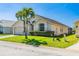 Attractive single-story home featuring a manicured lawn, mature palm tree, and well-maintained landscaping at 215 Elderberry Dr, Davenport, FL 33897