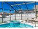 Relaxing screened-in pool and spa area with comfortable lounge chairs for enjoying the outdoors in privacy at 215 Elderberry Dr, Davenport, FL 33897