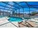 Enclosed pool area with in-ground spa, patio furniture, and screen enclosure for privacy at 215 Elderberry Dr, Davenport, FL 33897