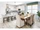 Well-lit kitchen with white cabinetry, modern appliances, a breakfast bar, and an adjacent dining area at 2305 Sirena Ln, Mount Dora, FL 32757