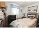 Cozy bedroom featuring a bed, vintage lamp, window, and blue walls at 24813 E Highway 316, Salt Springs, FL 32134