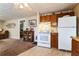 View of kitchen with white appliances and wooden cabinets next to the living room at 24813 E Highway 316, Salt Springs, FL 32134