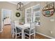 Dining area with hardwood floors, modern chandelier, and natural light pouring in through the large window at 252 Longhirst Loop, Ocoee, FL 34761