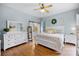 Bright bedroom with a barn door to bathroom, white furniture, and hardwood floors at 252 Longhirst Loop, Ocoee, FL 34761