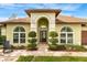 Inviting entryway features an arched entrance, lush landscaping, and a decorative front door at 2726 Babbitt Ave, Orlando, FL 32833