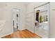 Hallway featuring wood floors, a white closet organizer, and a view into the bedroom with outside access at 2726 Babbitt Ave, Orlando, FL 32833