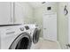 Bright laundry room with front loading Samsung washer and dryer, storage cabinets, and tile flooring at 2726 Babbitt Ave, Orlando, FL 32833