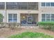 Exterior view of a screened-in patio with outdoor furniture and lush landscaping at 2847 Metro Sevilla Dr # 103, Orlando, FL 32835