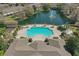 Aerial view of the community pool, surrounding patio, lake, and lush landscaping at 2847 Metro Sevilla Dr # 103, Orlando, FL 32835