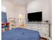 Bedroom featuring wood floors, white walls, bright decor, and tv on dresser at 3726 Mount Hope Loop, Leesburg, FL 34748