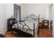 Cozy bedroom with a wrought iron bed frame, side tables and lamps, on wood floors at 3726 Mount Hope Loop, Leesburg, FL 34748