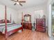 Bedroom with wooden floors, canopy bed frame, dresser, and lots of natural light at 3726 Mount Hope Loop, Leesburg, FL 34748