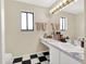 Bathroom featuring black and white flooring, a white sink, and a decorative mirror at 380 Morning Glory Dr, Lake Mary, FL 32746