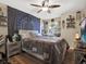 Cozy bedroom with a ceiling fan, hardwood floors, and decorative wall hangings at 380 Morning Glory Dr, Lake Mary, FL 32746