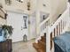 Bright foyer featuring tile floors, a staircase with white railings, and a view of the front door at 380 Morning Glory Dr, Lake Mary, FL 32746