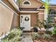 Up close shot of the front door with well manicured landscaping with an arch window above the door at 380 Morning Glory Dr, Lake Mary, FL 32746