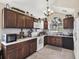 Spacious kitchen with brown cabinets, granite counters, tiled backsplash, and stainless steel appliances at 380 Morning Glory Dr, Lake Mary, FL 32746