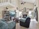 Bright living room with vaulted ceilings, tile floors, fireplace, and access to a staircase at 380 Morning Glory Dr, Lake Mary, FL 32746