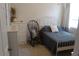 Cozy bedroom featuring neutral walls, dresser, a rocking chair, and a metal bed frame at 4110 Arlington Ridge Blvd, Leesburg, FL 34748