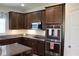 Modern kitchen with stainless steel appliances, dark wood cabinetry, and granite countertops at 4110 Arlington Ridge Blvd, Leesburg, FL 34748