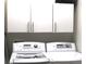 Clean laundry area showcases modern white washer and dryer units with matching cabinets at 4110 Arlington Ridge Blvd, Leesburg, FL 34748