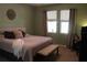 Cozy bedroom featuring warm tones, neutral decor, and ample natural light from the windows at 4110 Arlington Ridge Blvd, Leesburg, FL 34748
