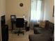 A comfortable home office setup with a desk, computer, sofa, and large window at 4110 Arlington Ridge Blvd, Leesburg, FL 34748