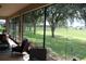 Relaxing screened-in patio with comfortable seating and picturesque views of the green space at 4110 Arlington Ridge Blvd, Leesburg, FL 34748