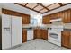 Functional kitchen featuring wood cabinetry, white appliances, and a window with a view at 414 Sundown Trl, Casselberry, FL 32707