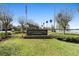 A clear view of the Plantation Garden Condominiums sign, set against a backdrop of trees and a serene lake at 4376 Lake Underhill Rd # C, Orlando, FL 32803