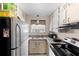 Efficient kitchen layout with granite countertops, white cabinetry, and stainless steel refrigerator at 4376 Lake Underhill Rd # C, Orlando, FL 32803