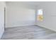 Bright, empty bedroom with light gray wood floors and a large window at 4415 Sw 169Th Lane Rd, Ocala, FL 34473