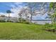 Expansive backyard sloping down to the lakefront, featuring mature trees and lush green grass at 443 Lakewood Dr, Winter Park, FL 32789